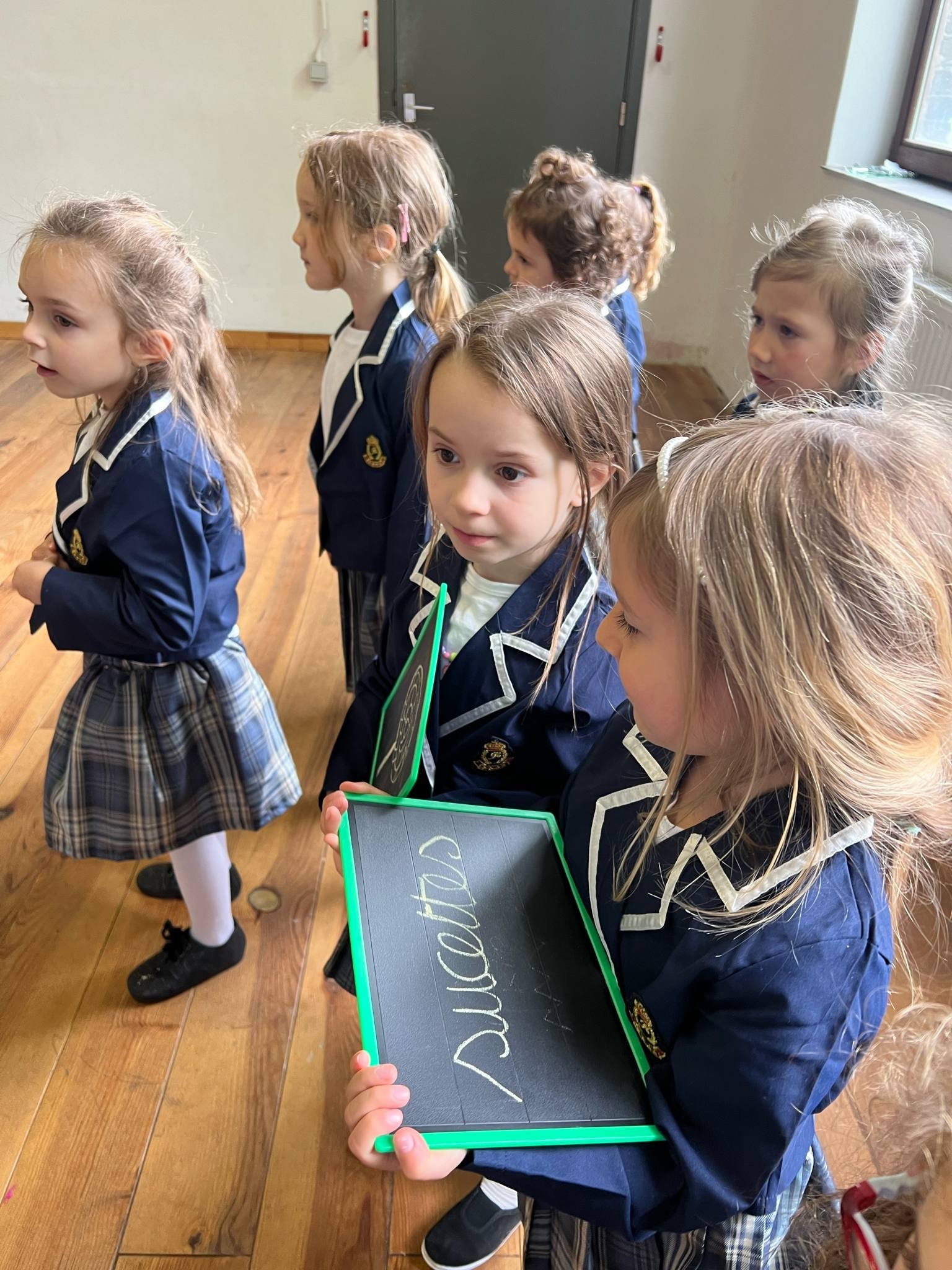 Fillettes en uniforme avec une ardoise